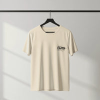 Beige t-shirt with 'Walk by Faith, Not by Sight' text on a hanger against a gray background