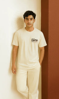Person wearing a white t-shirt with text standing against a plain background