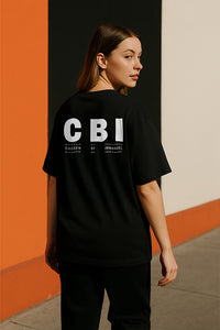 Person wearing a black t-shirt with 'CBI' text on the back against an orange and black background